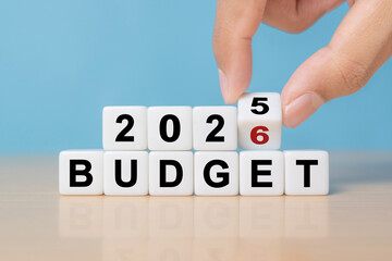 2026 Budget planning and allocation concept. Hand flips dice and changes the inscription 