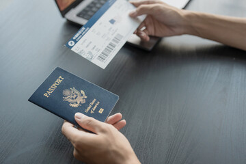 Hand Man Online booking and buying plane tickets using laptop phone and credit card Planning trip travel vacation with passport and ticket