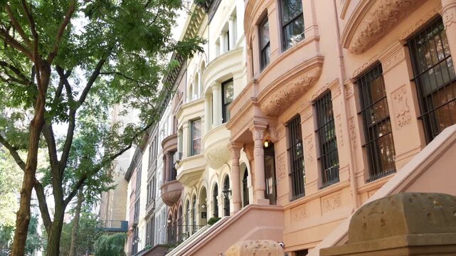 New York City townhouse buildings, brownstone row houses in Manhattan or Brooklyn, United States of America. Classic buildings on residential district street. Real estate property. Rowhouse townhome.