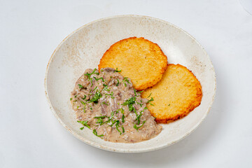 A rich meat stew with two golden-fried tortillas and fresh herb garnish