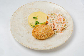 Croquette plated beside fluffy mashed potatoes and crunchy coleslaw, ready to savor the flavors