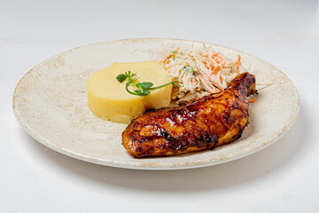 Grilled chicken with creamy mashed potatoes and crunchy coleslaw, beautifully served