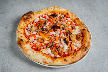 A mouthwatering pizza sits on a plate, showcasing vibrant toppings and a golden crust