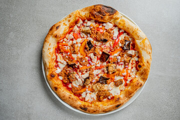 A round pizza with chicken, peppers, and onions invites everyone to enjoy!