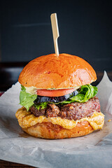 Succulent burger featuring lettuce, tomato, and pickles on a fresh bun ready to be devoured