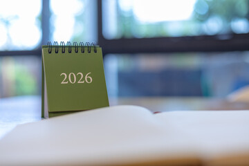 Close-up of a green desk calendar showing 2026 in a modern office setting. Ideal image for planning, time management, new year goals, productivity, or business organization themes.