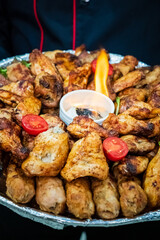 A colorful platter of tasty grilled chicken wings and juicy skewers, ideal for sharing