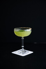 Vibrant Green Cocktail in Coupe Glass with Spiced Rim