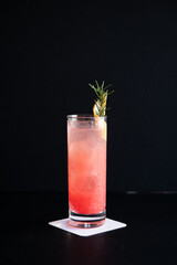 Refreshing Pink Cocktail with Rosemary and Citrus Garnish