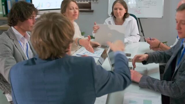 Team members or business partners shaking hands at the end of a productive meeting in a modern office. Positive atmosphere, mutual agreement and successful collaboration reflected in gestures. 