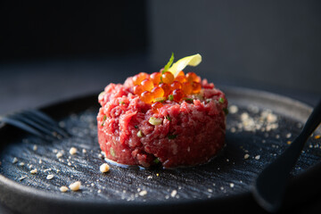 Gourmet Beef Tartare with Ikura and Yolk on Dark Plate