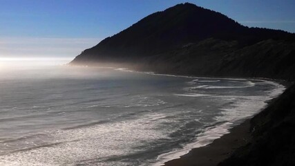 A moonlit nighttime timelapse of Humbug Mountain on the Oregon coast, featuring gentle ocean swells and waves breaking softly along the shoreline, 20 seconds.  - Powered by Adobe