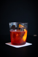 Classic Red Cocktail with Orange Peel and Star Anise on Dark Background