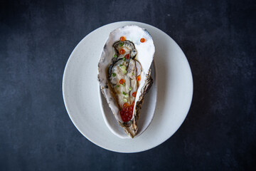 Gourmet Oyster with Red Caviar on a White Plate