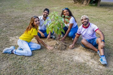 Diverse friends planting a tree for environmental conservation