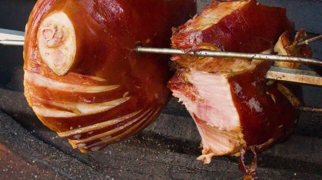 Traditional Pork Knuckle Rotating on Spit Over Wood Fire in Prague