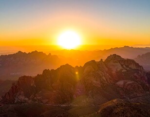 Aerial view of a sunrise illuminating rocky mountain peaks