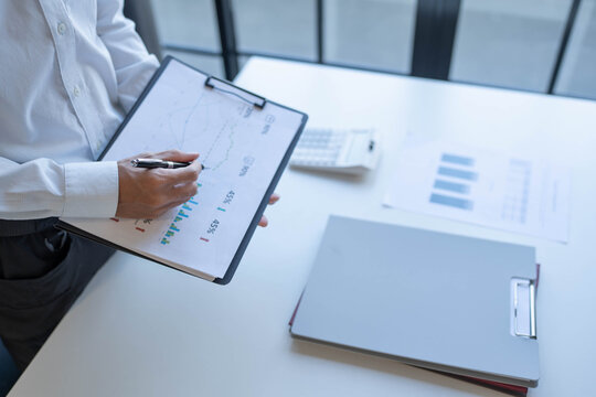Businessman standing chekking documents with pen