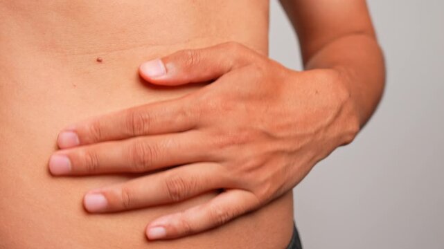 A hand massages the abdomen in gentle clockwise circles around the navel to ease constipation and release gas, reflecting digestion, wellness, relief, relaxation, circulation, balance, and self-care.
