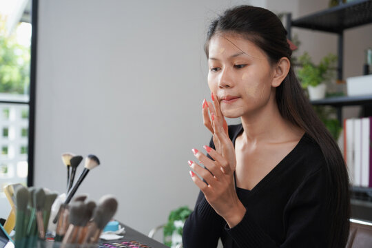 Asian woman influencer beauty blogger live streaming reviews her cosmetics on online platform