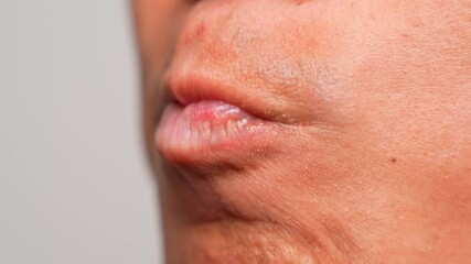 A person purses their lips and circles their tongue around, an action commonly linked to nervousness, internal conflict, or a need for comfort, revealing hidden feelings or suppressed emotions.
