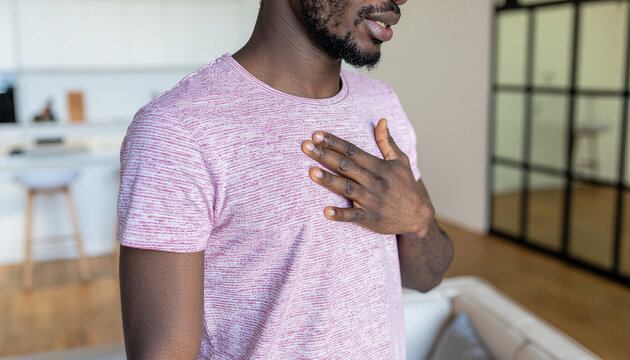 A man clutches his chest because he has sudden heart pain. Symbol for heart attack or other heart conditions