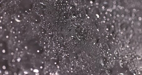 wet old glass lies on a black slate board with an uneven texture, not broken transparent glass used in construction covered with water droplets - Powered by Adobe