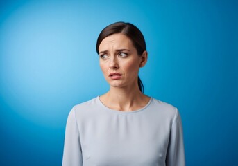 A woman with a worried expression, looking off to the side, against a blue background.