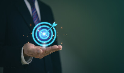 Businessman holding glowing target icon, symbolizing goal achievement, business strategy, and success, goal setting.