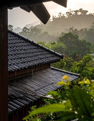 View of a tiled roof in the rain, with lush green foliage and a misty mountain in the background under an overcast sky