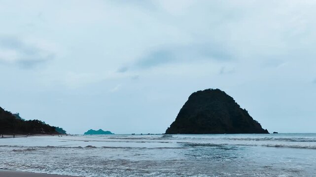 A summer view of a tropical island in East Java Banyuwangi with blue sky, clear water, and dramatic rock formations along the coastline