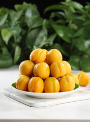 Fresh Ripe Apricots on White Plate with Green Leaves Background - Organic Stone Fruits