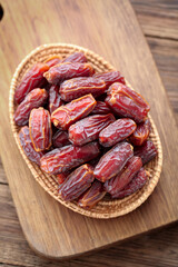 Golden dried dates in wicker basket on wooden board - Middle Eastern healthy snack from UAE Xinjiang