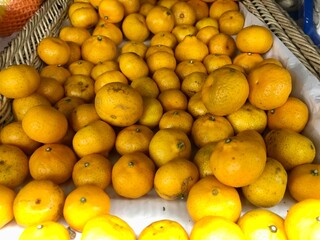 Baby tangerines on a store display. The tangerines are of poor quality.
