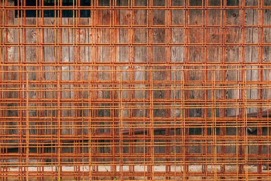 Closeup of rusty reinforcing steel mesh used in construction. Corroded steel reinforcement grid texture background.