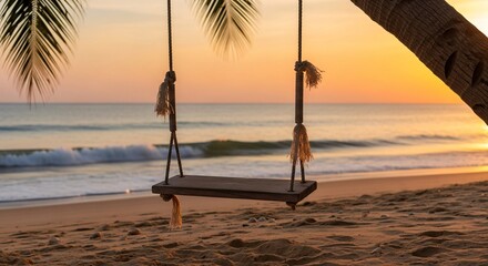 Wooden swing hanging from palm tree on a sandy beach at sunset