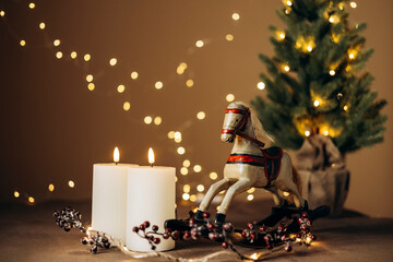 Rocking horse and Christmas decoration on brown background.
