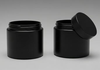 Two matte black plastic cosmetic jars with lids one open showcasing inner packaging potential for beauty products