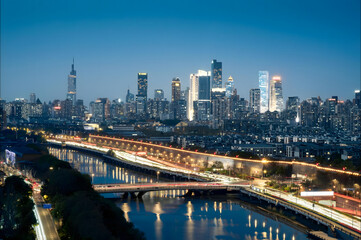 Fototapeta premium Manhattan Skyline at Blue Hour with Illuminated Bridge and River Reflections
