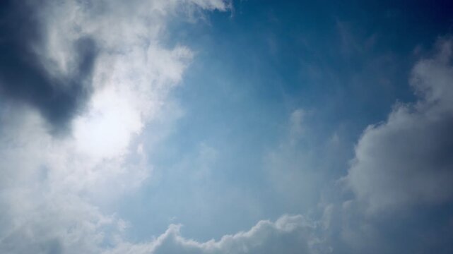 Bright sky with sunlight breaking through soft drifting clouds in natural motion  recorded at normal speed showcasing atmospheric depth cloud motion natural lighting shifts and real time movement perf