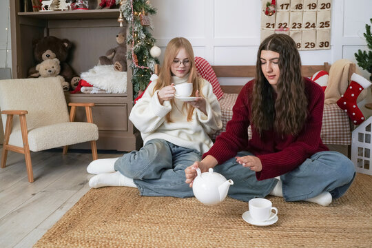 Friends enjoy tea together in a cozy holiday setting during winter afternoon