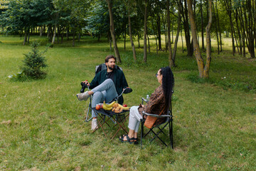 Enjoying a relaxing picnic outdoors with friends in a green park setting on a sunny day