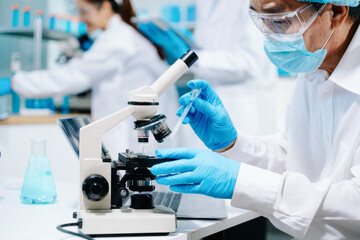 A scientific research team collaborating in a modern laboratory, conducting experiments, analyzing...