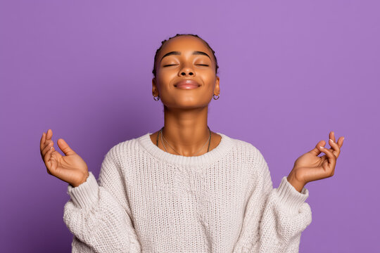 Serene dark-skinned woman practicing mindfulness meditation for stress relief on a calming violet background, promoting wellness and positive mental health