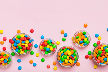 different colored round candy in bowl and jars. Top view of large variety sweets and candies with copy space