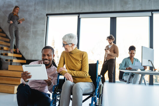 A diverse group of young professionals, including senior businesswomen entrepreneur in a wheelchair