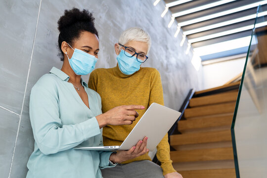 Busy business people, programmers software developer engineer working on computer in office in masks - Powered by Adobe