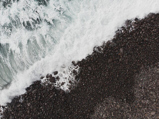 Aerial View of Waves Crashing on Rocky Shoreline