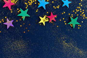 Colorful glitter stars on dark blue background with space for text