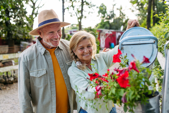 Happy elderly couple enjoying gardening in countryside.